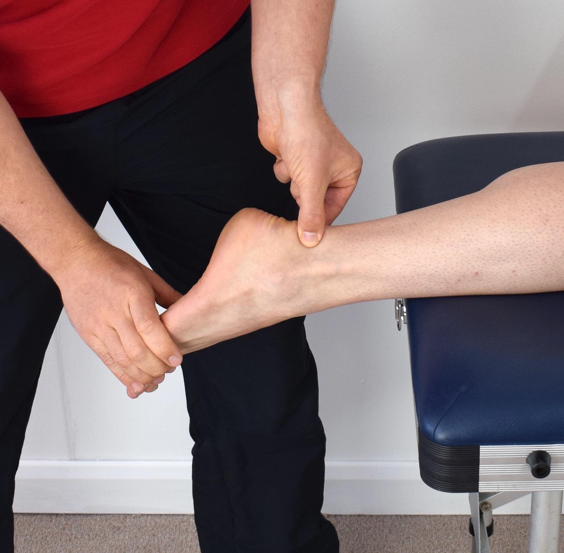 A therapist assessing and treating a runner’s ankle