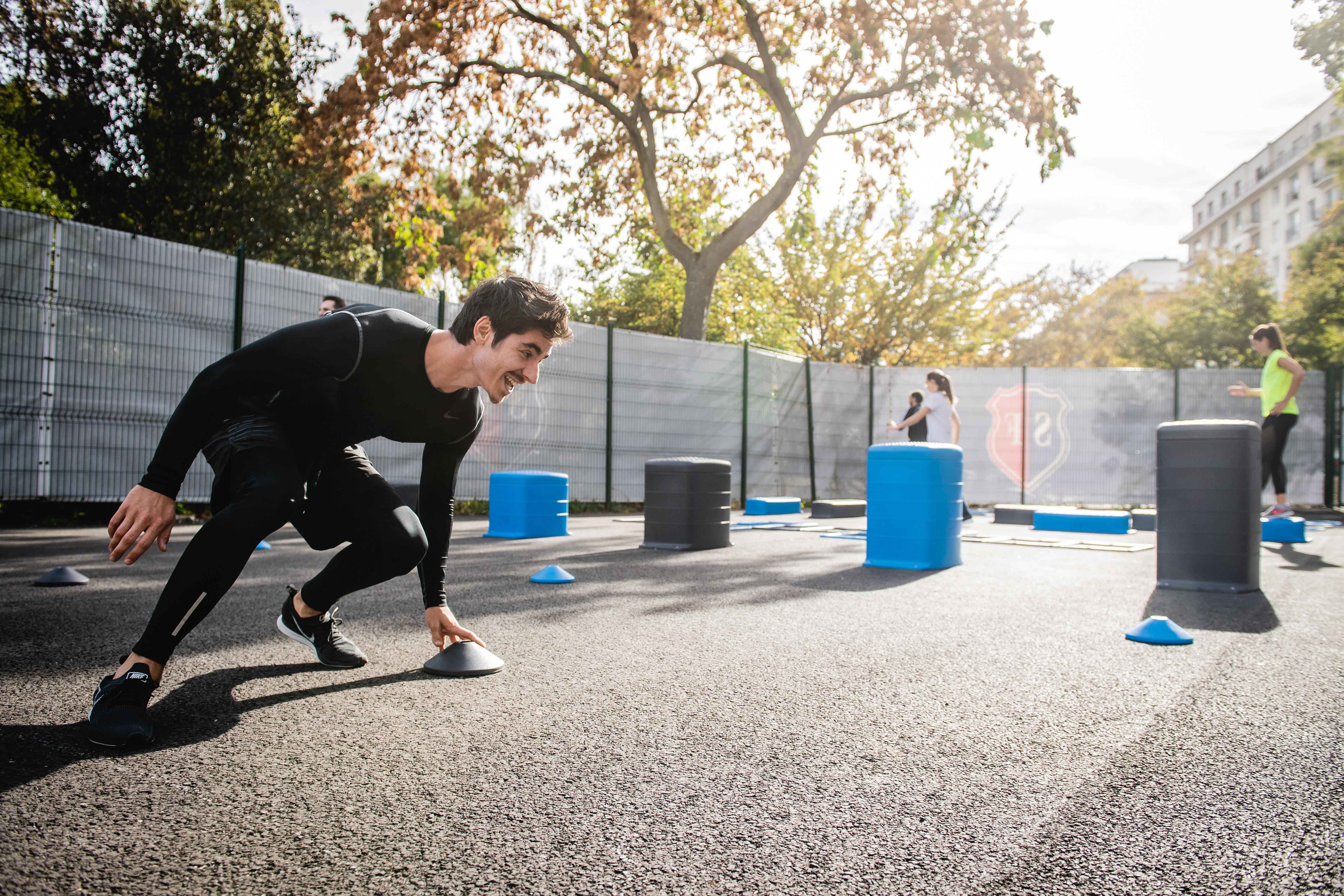 A coach timing runners during an outdoor running session